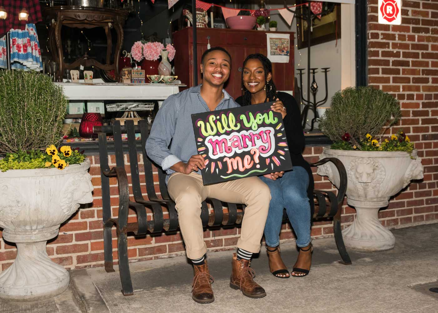 Engagement photo holding a will you marry me sign